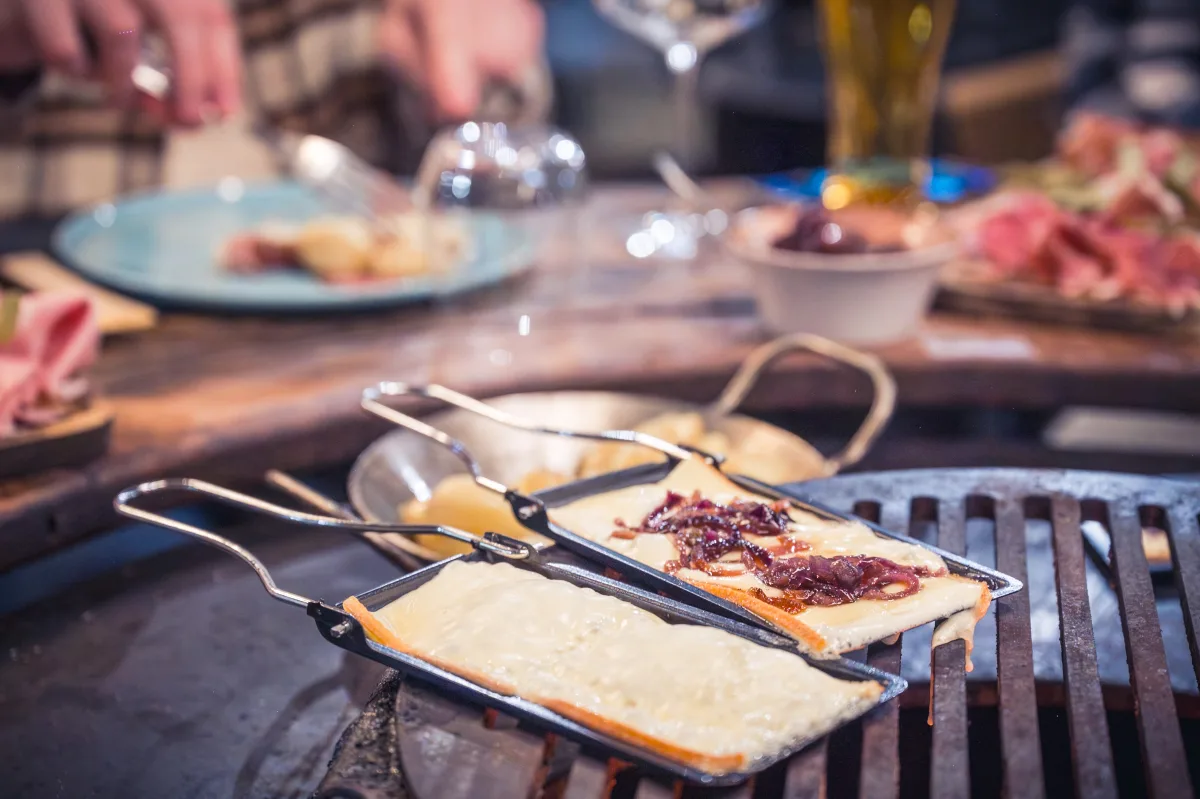 Fromage à raclette fondant au-dessus des braises