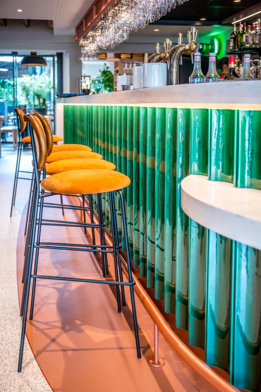 Le bar vert et ses tabourets orange
